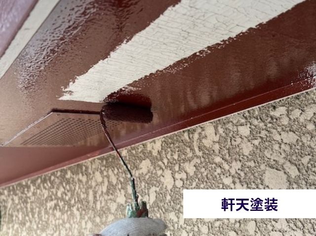 軒天をチョコレート色の塗料で塗装する様子